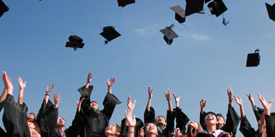 graduates throwing caps into the air